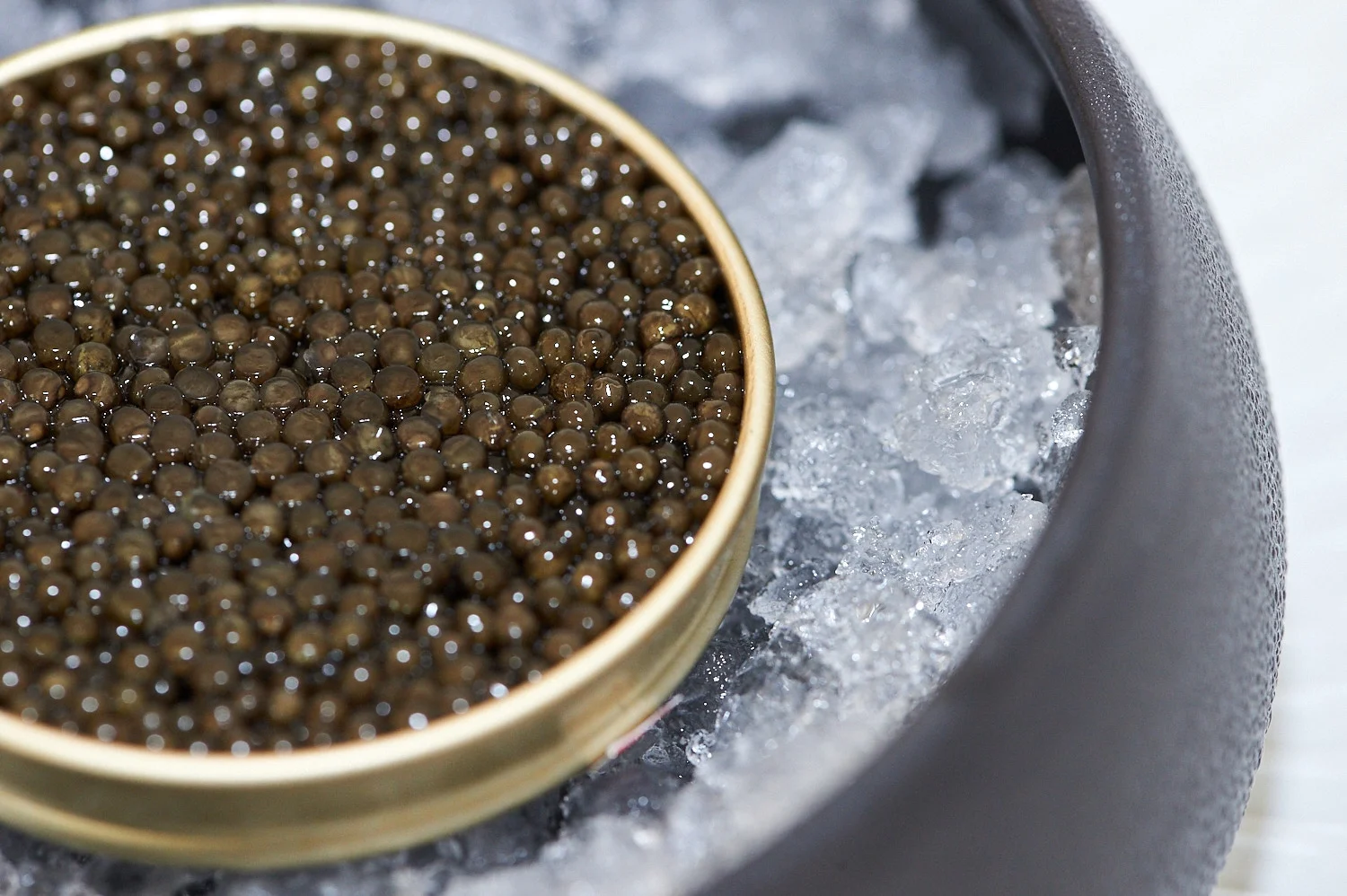 Packshot caviar Sturia — boîte métallique sur glace pilée