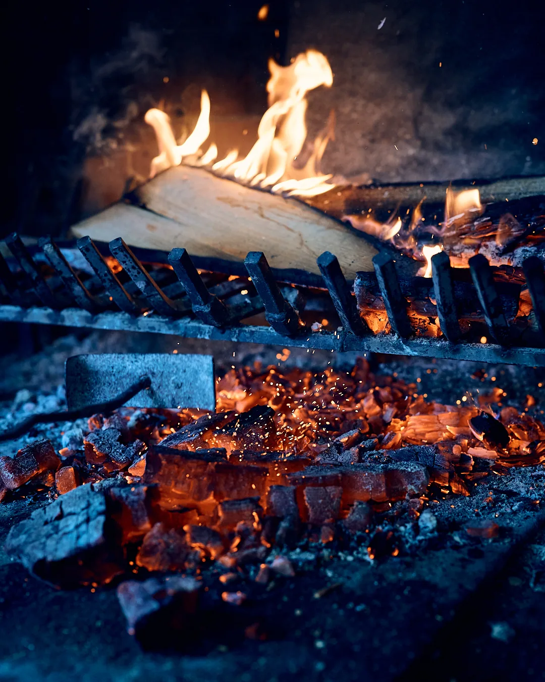 Braises incandescentes sous le gril au feu de bois, restaurant La Cheminée de Mamie